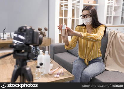 female vlogger home with camera face mask