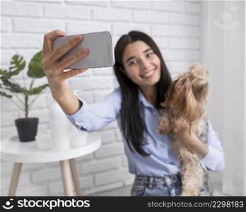 female vlogger home with smartphone dog