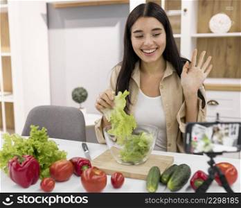 female vlogging home with smartphone vegetables