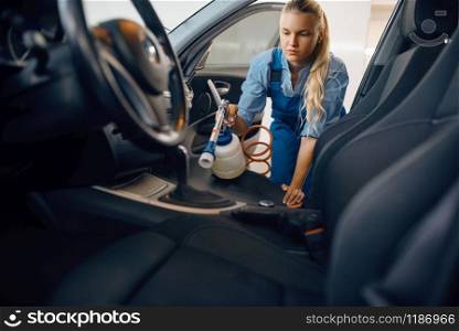 Female washer cleans automobile interior, car wash. Woman washes vehicle, carwash station, car-wash business. Female washer cleans automobile interior, car wash