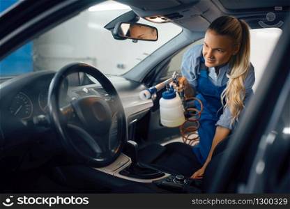 Female washer cleans automobile interior, car wash. Woman washes vehicle, carwash station, car-wash business