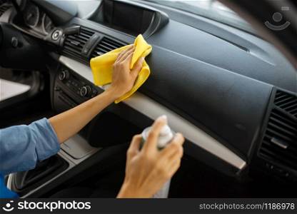 Female washer with polish spray cleans automobile interior, car wash service. Woman washes vehicle, carwash station, car-wash business