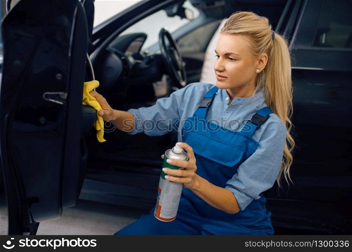 Female washer with sponge cleans automobile door trim, car wash service. Woman washes vehicle, carwash station, car-wash business. Female washer cleans automobile door trim