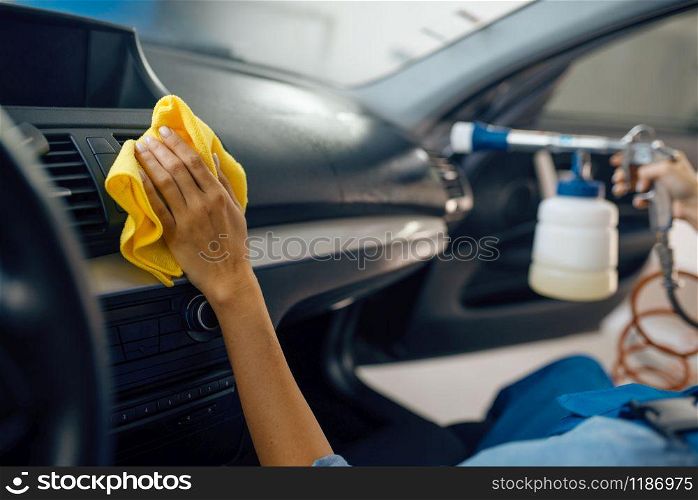 Female washer with sponge cleans automobile interior, car wash service. Woman washes vehicle, carwash station, car-wash business. Female washer with sponge cleans car interior