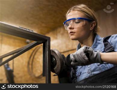 female welder using angle grinder