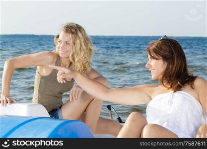 female with friend pointing with her finger on pedal boat