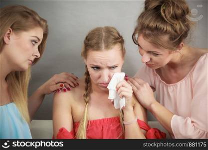 Female women comforting her woman friend while she is having cold flue blowing runny nose into paper tissue.. Friends helping woman during fever.