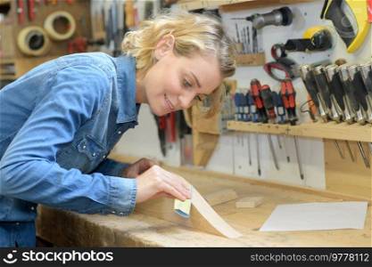 female woodworker wood sanding
