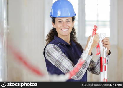 female worker erecting exclusion chain in renovation property