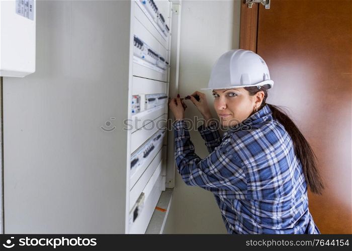 female worker fixing a fuseboard