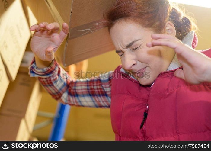 female worker hitting her head by accident into shelf