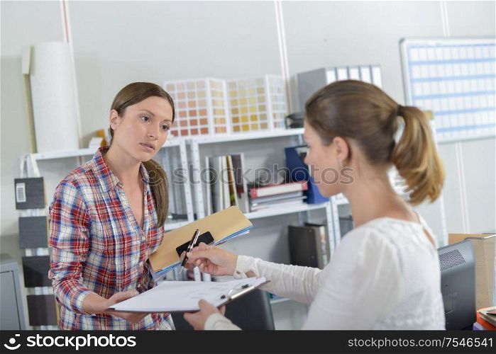 female worker is handing over a document