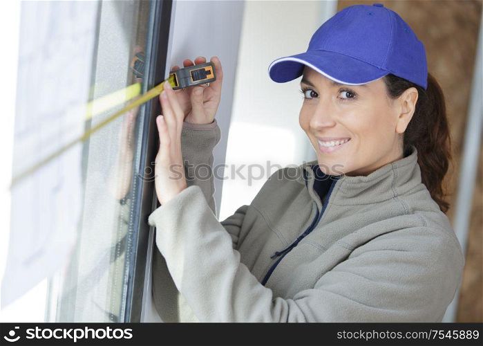 female worker measures a window