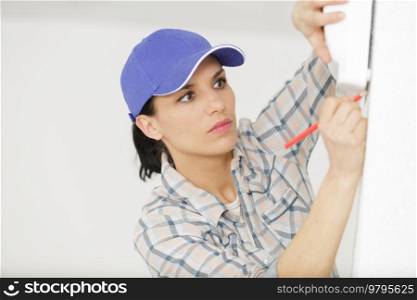 female worker measuring a wall
