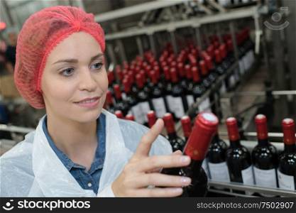 female worker using machine to work at wine factory