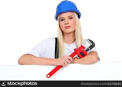 Female worker with a wrench and board left blank for your image