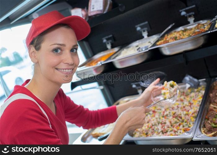 female working at serving trays of pasta