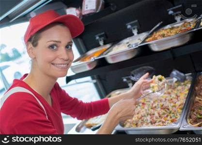 female working at serving trays of pasta
