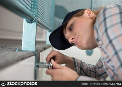 female working on a metal bolt