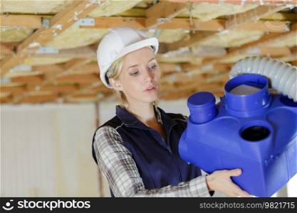 female working on industrial pipe
