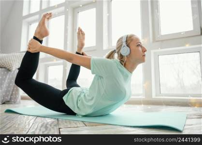 female working out mat listening music