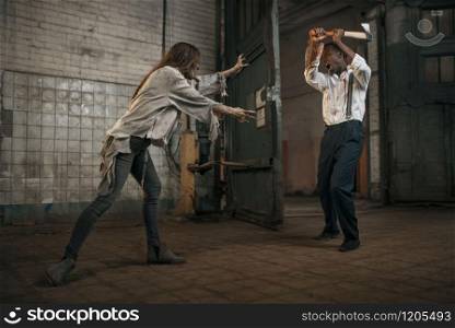 Female zombie fights with scaried man in abandoned factory. Horror in city, creepy crawlies, doomsday apocalypse, bloody evil monsters
