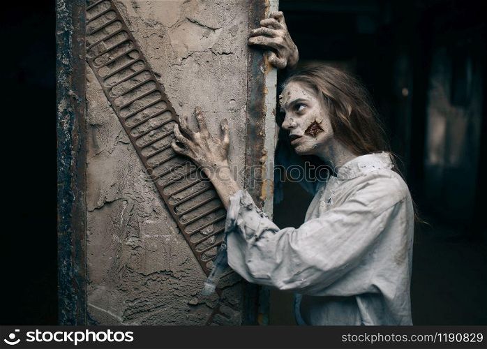Female zombie in abandoned factory, devil. Horror in city, creepy crawlies attack, doomsday apocalypse, bloody evil monsters. Female zombie in abandoned factory, devil