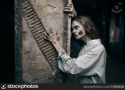 Female zombie in abandoned factory, devil. Horror in city, creepy crawlies attack, doomsday apocalypse, bloody evil monsters. Female zombie in abandoned factory, devil