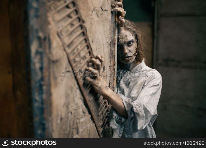 Female zombie in abandoned factory, devil. Horror in city, creepy crawlies attack, doomsday apocalypse, bloody evil monsters