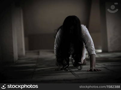 Female zombie in blood. Asian Woman ghost with blood. Horror scary fear in dark house creepy crawling move slowly creeping out. Hair covering face her eye looking camera, Halloween festival concept