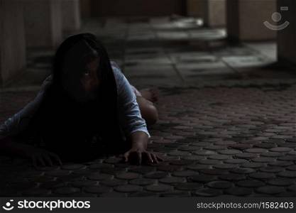 Female zombie in blood. Asian Woman ghost with blood. Horror scary fear in dark house creepy crawling move slowly creeping out. Hair covering face her eye looking camera, Halloween festival concept