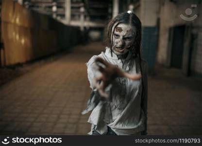 Female zombie searching fresh meat in abandoned factory, scary place. Horror in city, creepy crawlies attack, doomsday apocalypse, bloody evil monsters