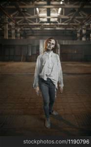 Female zombie walking in abandoned factory, scary place. Horror in city, creepy crawlies attack, doomsday apocalypse, bloody evil monsters. Female zombie walking in abandoned factory, horror