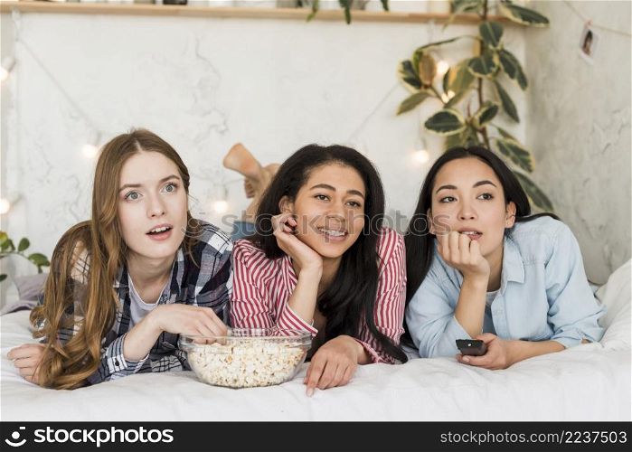 females lying bed watching tv