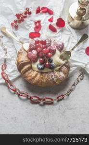 Feminine background with pudding bun, two gold forks, berries, flowers and red necklace . Sweet fashion.