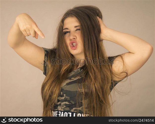 Feminine beauty concept. Portrait of beautiful young woman with long brown hair wearing stylish camo pattern tshirt. Beautiful young woman with brown hair