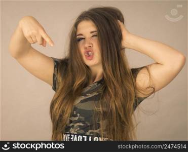 Feminine beauty concept. Portrait of beautiful young woman with long brown hair wearing stylish camo pattern tshirt. Beautiful young woman with brown hair