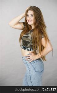 Feminine beauty concept. Portrait of beautiful young woman with long brown hair wearing stylish camo pattern tshirt and jeans. Beautiful young woman with brown hair