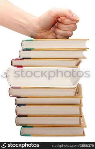 Feminine fist on pile of the books insulated on white background