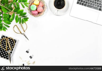 Feminine office table with coffee, cookies, laptop computer and green plant on white table background. Flat lay