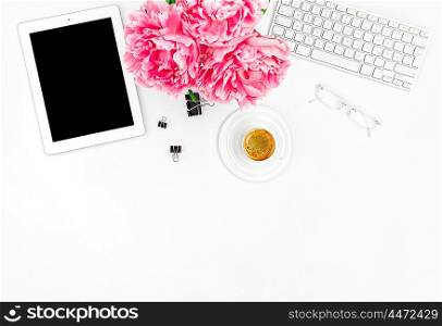 Feminine office workplace with coffee and flowers. Mockup with digital Tablet PC. Flat lay for social media blogger