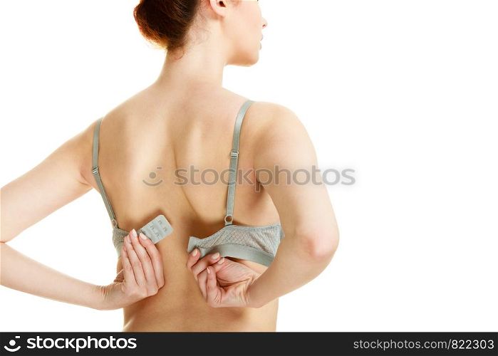 Femininity, brafitting, underwear, underclothes concept. Attractive slim woman take her grey bra off. Studio shot on white background. Attractive slim woman taking off grey bra