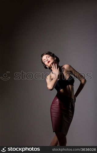 Femininity. Elegant Daydreaming Woman posing in Studio over Grey Background