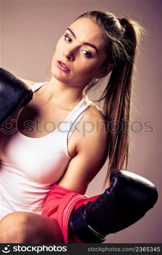 Feminist and emancipation idea. Woman in male occupation, training, boxing. Fit female fitness girl doing exercise in studio. Retro and vintage photo.