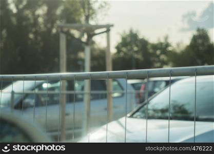 Fence around a parking lot with cars