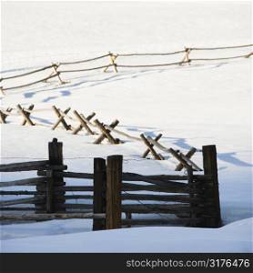 Fence in snow covered landscape.