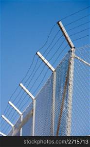 Fence of restricted area against blue sky
