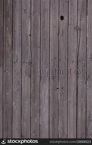 fence of vertical old brown purple planks or side of farm shed