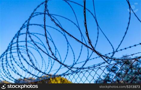 Fence with a barbed wire under a blue sky