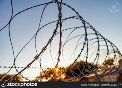 Fence with a barbed wire under a blue sky